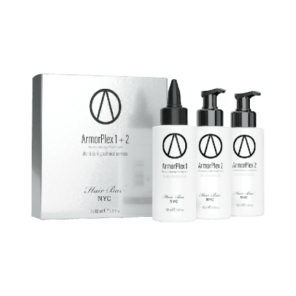 A silver ArmorPlex Restructuring Treatment box stands beside three white pump-top bottles with matching logos, all Hair Bar NYC products. Designed for after-care and salon use, they're displayed against a white background.
