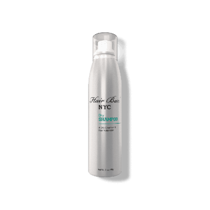 A tall silver aerosol can labeled Dry Shampoo stands upright on a white background, featuring a transparent cap and minimalistic black and teal text describing it as a dry cleanser for hair.
