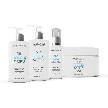 The Silk Touch System Duo Bundle by Hair Bar NYC features white bottles with minimalist black and blue text, displayed side by side on a white background. Products include a shampoo, conditioner (both pump bottles), serum, and a mask (in a round jar).