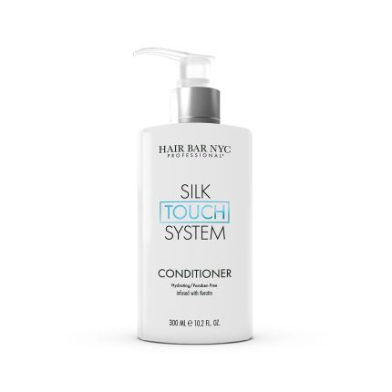 A 300 mL white pump bottle labeled "Silk Touch System Conditioner" by Hair Bar NYC sits against a white background, featuring hydrating, paraben-free, and keratin-infused formula.