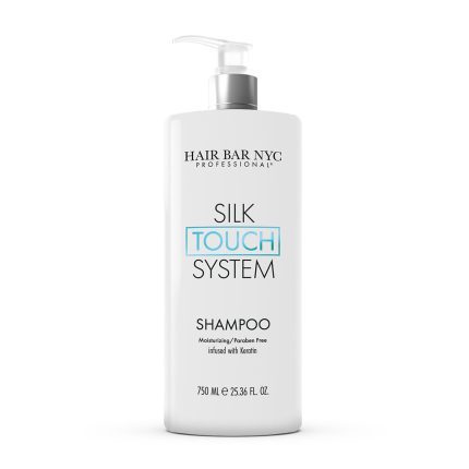 A white 750 ml pump bottle labeled "Silk Touch System Shampoo" with "TOUCH" in blue, featuring “Moisturizing / Paraben Free infused with keratin.”.