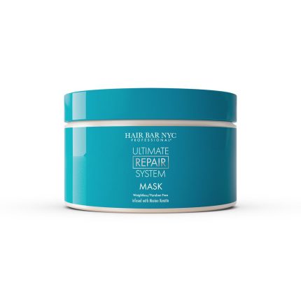 A teal round plastic container with a white lid labeled Ultimate System Repair Mask sits on a white background. The paraben-free, weightless mask is infused with native keratin for hair repair.