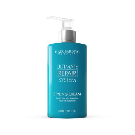 A teal 300 mL (10.2 fl oz) pump bottle of Ultimate Repair System Styling Cream sits on a white background, highlighting color-safe, paraben-free benefits plus marine keratin infusion.